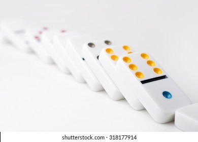 The Domino Effect Of White Blocks, With Colorful Numbers. Selective Focus On The Front Part Of The Domino Blocks. White Background.