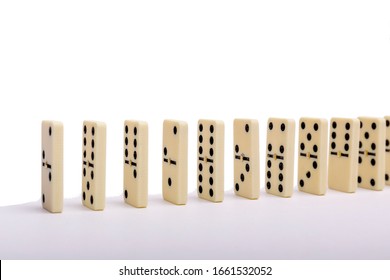 Domino's effect composition of a multiple domino bones placed in a row in white background.