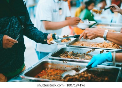 donate food to the homeless  The hands of the poor handed a plate to receive food from volunteers to alleviate hunger - Shutterstock ID 1807194196