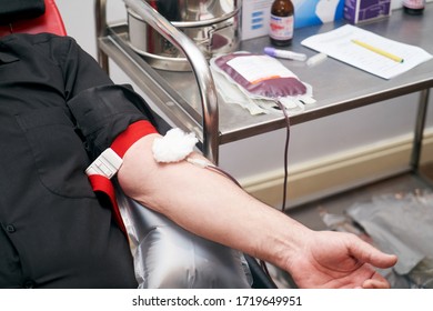 Donating Blood In Hospital, Close-up. Blood Donor At Donation Station. COVID-19 Coronavirus Survivor Patient Donating Blood Plasma