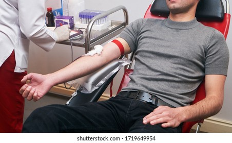 Donating Blood In Hospital, Close-up. Blood Donor At Donation Station. COVID-19 Coronavirus Survivor Patient Donating Blood Plasma