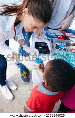 Donating her time and medical expertise to her community. Shot of a volunteer doctor giving checkups to underprivileged kids.