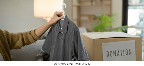 Donation, asian young woman sitting pack object at home, putting on stuff into donate box with second hand clothes, charity helping and needy people. Reuse recycle - Powered by Shutterstock