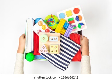 Donation Box With Baby Kid Toys, Books, School Supplies, Clothing For Charity On White Background. Top View