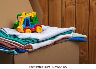 Donation box with children's things, toys. Donation box full with stuff for donate. Help poor. Case full of clothing for poor families. Sharity social activity. Cardboard box with clothes for charity.