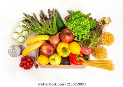 Donation Box With Fresh Fruit And Vegetables, Eggs, Pasta And Canned Food. Food Delivery And Shopping Concept. Vegetarian Grocery Products, Isolated On White Background. Top View.