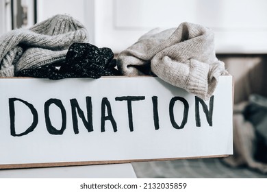 Donation Box With Old Used Clothes Indoors. Happy Charity. Winter Clothes In A Cardboard Box. Clothing Donation Or Recycling