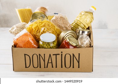 Donation Box With Various Food. Open Cardboard Box With Oil, Canned Food, Cereals And Pasta.