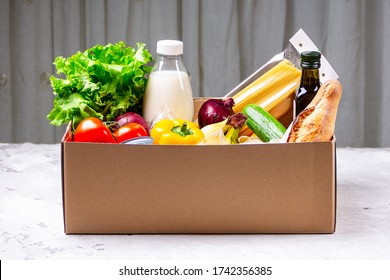 Donation Box With Various Food. Open Cardboard Box With Oil, Vegetables, Milk, Canned Food, Cereals And Pasta. Food Delivery Concept With Space For Text.