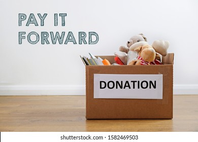 Donation Concept: Box Full Of Books And Toys. Pay It Forward