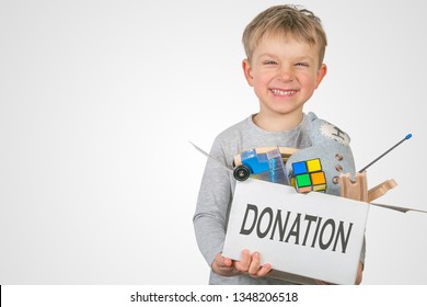 Donation concept - boy holding box with toys for donation, copy space, isolated