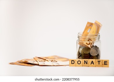 Donation concept. Donation jar with coins, euro and wooden letters - Shutterstock ID 2208377955