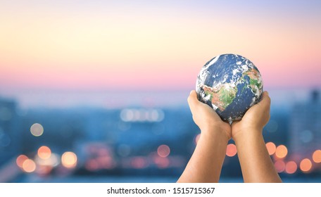 Menschliche Hände, die die Erde global auf unscharfem nächtlichem Hintergrund in der Stadt halten. Von der NASA bereitgestellte Elemente dieses Bildes