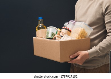 Donation Help Box Full Of Supplies. Volunteer In Protective Medical Hand Gloves Holding Food Box For Delivery Charity 