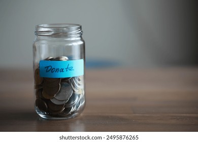 Donation Jar Filled with Coins on Wooden Table for Charity and Fundraising Campaigns - Powered by Shutterstock