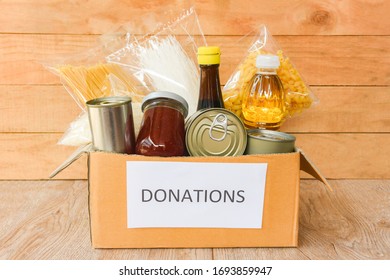 Donations Box With Canned Food On Wooden Table Background / Pasta Canned Goods And Dry Food Non Perishable With Cooking Oil Rice Noodles Spaghetti Macaroni Donations Food Concept