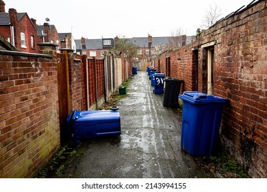 DONCASTER, UK - MARCH 2, 2022. The Backstreet Of Rows Of Terraced Houses In A Run Down City In Northern England With Wheelie Bins Left Out For Roadside Collection With Copy Space