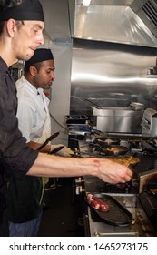 Doncaster, UK - May 11 2019: Two Chefs Hard At Work Cooking A Busy Saturday Night Dinner Service On 11 May At La Boca Argentine Steak House Restaurant, 1 Netherhall Road