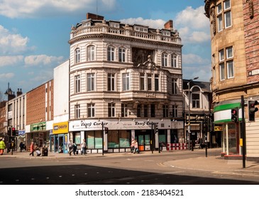 Doncaster, Yorkshire, England- April 19, 2016. Silver Street With 
1910 Building. Tasty Corner Sign And People Walking On The Street.