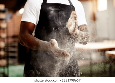 Done and dusted. an unrecognizable male baker dusting the flour off his hands. - Powered by Shutterstock