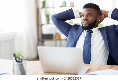 Done work. Satisfied african businessman resting at office, sitting with hands behind head at workplace, empty space - Shutterstock ID 1428582389