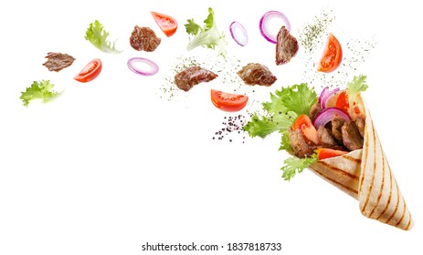 Doner kebab or shawarma with ingredients floating in the air: beef meat, lettuce, onion, tomatos, spice. White background. Copy space.