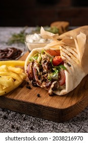 doner kebab, a shawarma in a pit of fresh vegetables and meat. with large spices. restaurant serving. on a dark background. for menus and ads