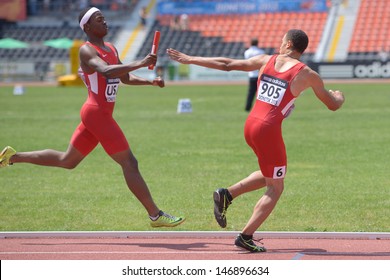 DONETSK, UKRAINE - JULY 13: USA team member Ryan Clark (left) pass the baton to Taylor McLaughlin in the boys medley relay during World Youth Championships in Donetsk, Ukraine on July 13, 2013