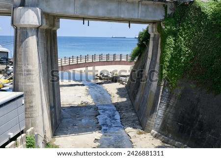 Donghae City, South Korea - July 28th, 2019: Gazing through a brick tunnel underpass, a serene stream flows from Donghae City, meandering through Hanseom Beach into the vast East Sea.