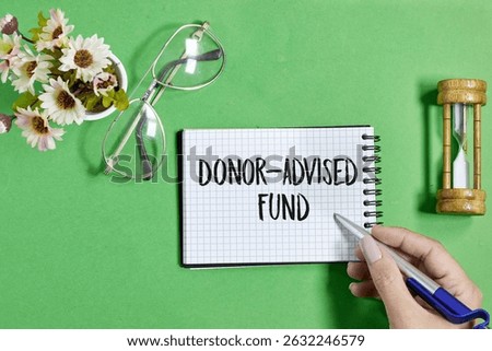 Donor-Advised Fund Concept with Notebook, Pen, and Symbolic Objects on Green Background