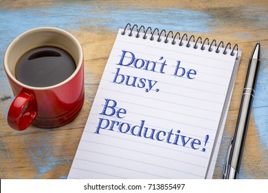 Don't be busy. Be productive. Handwriting in a spiral notebook with a cup of coffee.
