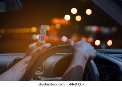 Don't drink and drive concept, Drunk and driving a car at night with a bottle of alcohol - Shutterstock ID 544683007