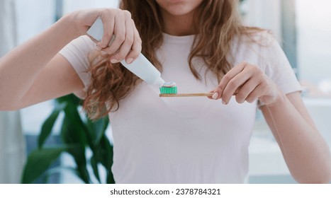 Dont forget to brush your teeth twice a day. Shot of a young woman applying toothpaste to a toothbrush. - Powered by Shutterstock