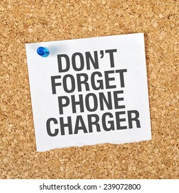 Don't Forget Phone Charger Message On Reminder Note Pinned To A Cork Memory Bulletin Board.