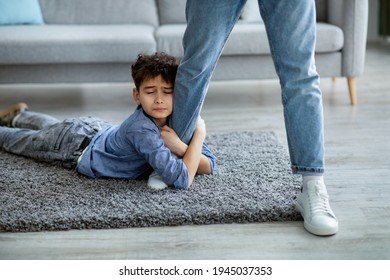 Don't Go, Dad. Upset Boy Embracing His Father Leg, Begging Daddy To Stay With Him, Lying On The Floor Carpet. Sad Son Holding Man And Close Eyes