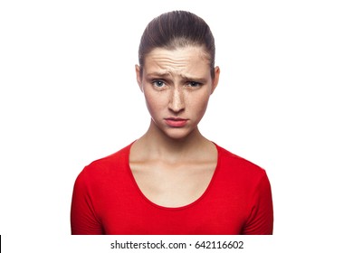 I Don't Know. Portrait Of Funny Confused Woman In Red T-shirt With Freckles. Looking At Camera, Studio Shot. Isolated On White Background. 