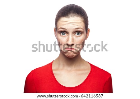 I don't know. portrait of funny confused woman in red t-shirt with freckles. looking at camera, studio shot. isolated on white background. 
