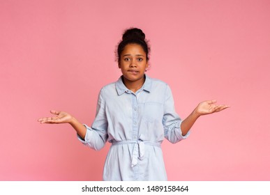 I Don't Know. Unsure African Girl Shrugging Shoulders On Pink Studio Background.