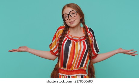 I Dont Know What To Say. Confused Redhead Girl Feeling Embarrassed About Ambiguous Question, Having Doubts, No Idea, Being Clueless And Uncertain. Teenager Ginger Child Kid On Blue Studio Background