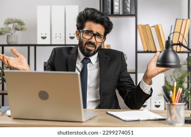 I dont know what to say. Confused business man working on laptop at office workplace. Freelancer feeling embarrassed about ambiguous question, having doubts, no answer idea, being clueless, uncertain