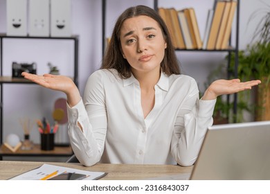 I dont know what to say. Confused business woman works on laptop at office workplace. Freelancer feeling embarrassed about ambiguous question, having doubts, no answer idea, being clueless, uncertain