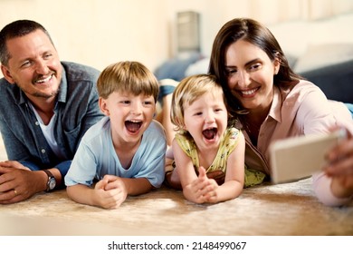 Dont Need To Ask Kids Twice To Take A Selfie. Shot Of A Happy Young Family Taking Selfies Together At Home.