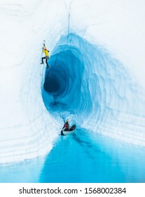 Don't Pop the Boat! - An ice climber leading up from inflatable canoe in a glacier lake on the Matanuska Glacier in Alaska.