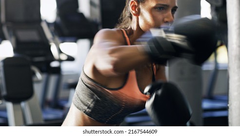 Dont pull your punches. Cropped shot of a young female boxer working out on a punching bag in the gym. - Powered by Shutterstock