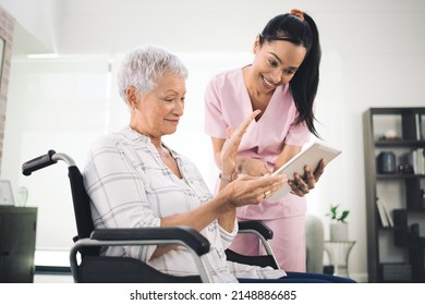 Dont Shrink To Fit In Child, Let Them Choke. Shot Of A Young Nurse Sharing Information From Her Digital Tablet With An Older Woman In A Wheelchair.