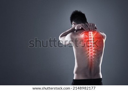 Dont take risks with a back injury. Rearview shot of a young man in the studio with cgi highlighting his back injury.