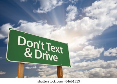 Don't Text And Drive Green Road Sign With Dramatic Sky, Clouds And Sun.