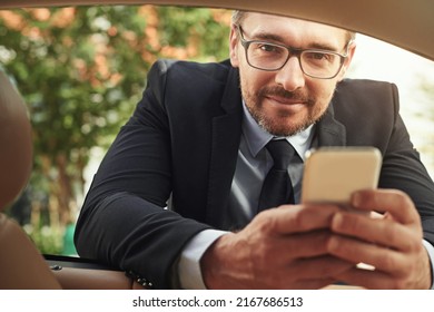 I Dont Text And Drive. Shot Of A Businessman Using A Phone While Leaning Against His Car.