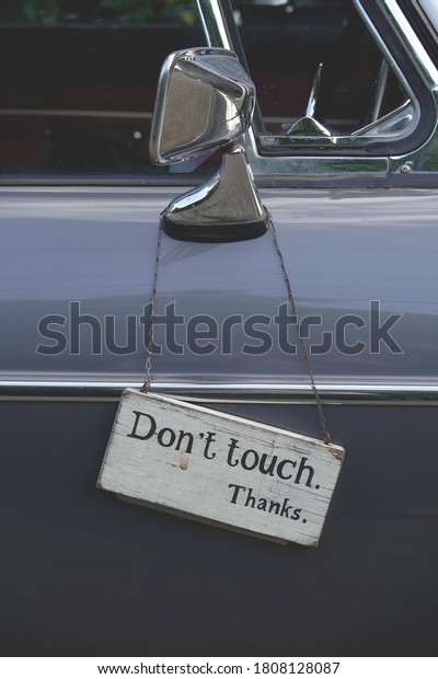 Don\'t\
touch sign haning on the side window of old\
car