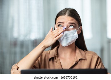 Don't Touch Your Face. Girl wearing surgical mask rubbing her eye with dirty hands, working on laptop - Shutterstock ID 1686730192